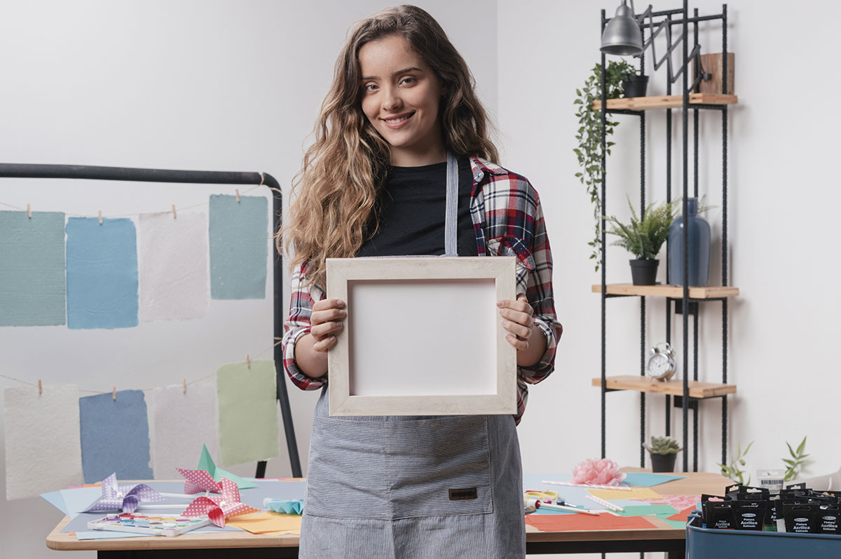 chica joven creando un paspartú a medida en su taller de manualidades