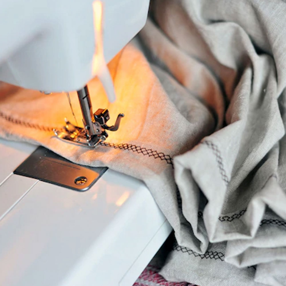 Máquina de coser trabajando en telas para tapizar sofás - Servei Estació